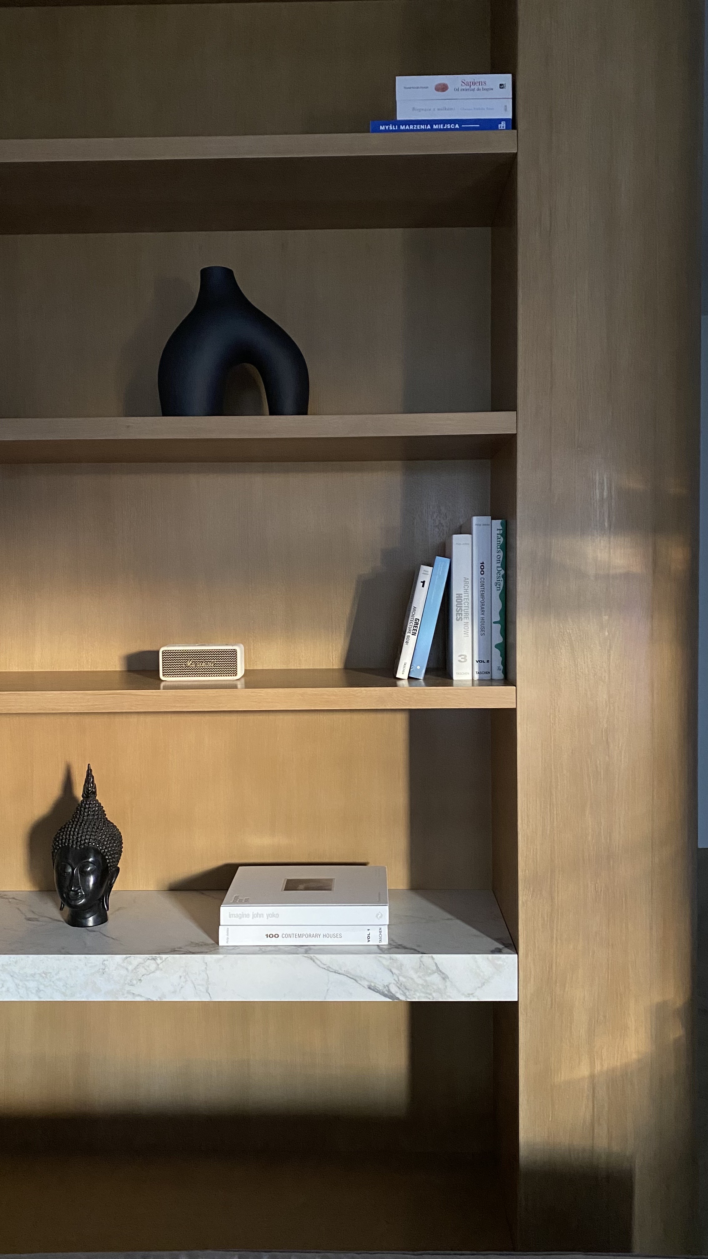Zabudowa biblioteczna z ciepłego dębu z marmurową półką i dekoracjami — realizacja Moore